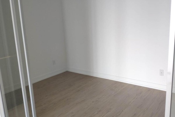 Empty room with white walls and light wood-look laminate flooring. - 2617 - 85 Wood Street, Toronto