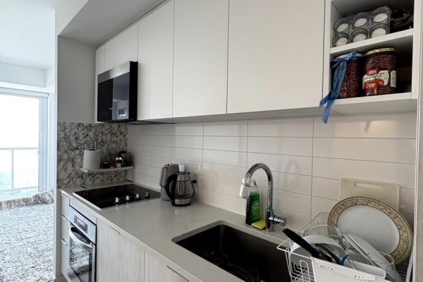 Modern kitchen with white cabinets, stainless steel appliances, and white subway tile backsplash. - 2619 - 2031 Kennedy Road, Toronto