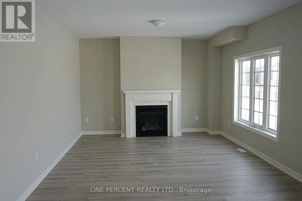 Empty dining room with gray laminate flooring, a large window, and a view of the front entrance. - 262 Springfield Crescent, Clearview