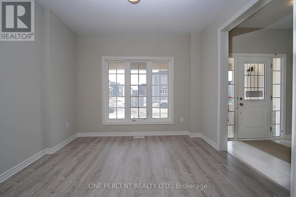View from the dining room to the foyer and staircase, with an opening to the kitchen. - 262 Springfield Crescent, Clearview
