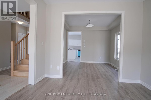 View from the dining room into the living room with two large windows and beige walls. - 262 Springfield Crescent, Clearview