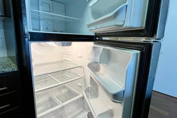 Interior view of an open stainless steel refrigerator with multiple shelves. - 2621 - 135 Village Green Square, Toronto