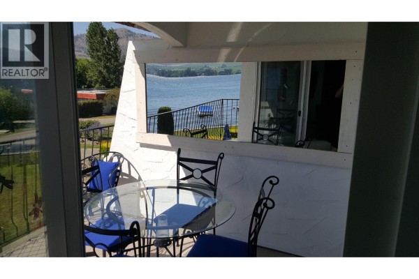 View from balcony through window to lake and distant mountains. - 2621 85th Street Unit# 202, Osoyoos