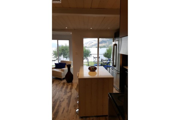 Kitchen island and living room with lake view beyond. - 2621 85th Street Unit# 202, Osoyoos