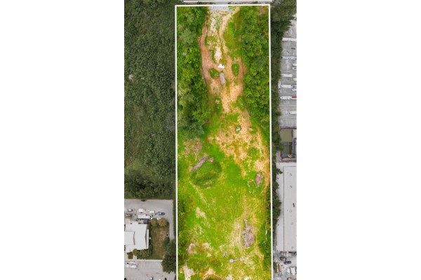 Top-down aerial view of the long, narrow lot showing varied terrain with grass, dirt, and scattered trees. - 26264 30a Avenue, Langley