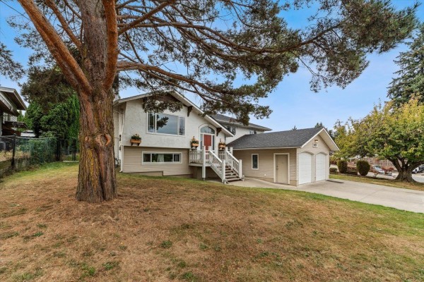 Side view of the house with a large tree in the foreground. - 2629 Sunnyside Crescent, Abbotsford