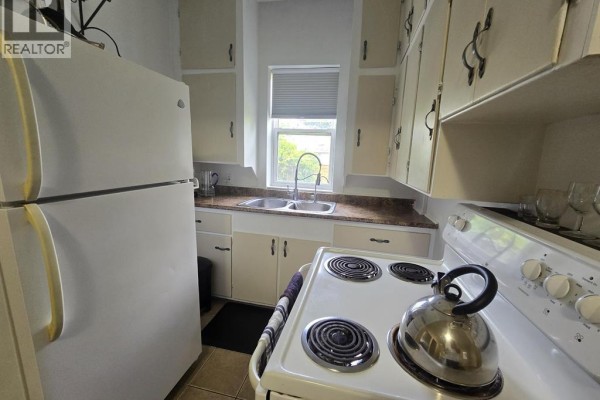 Kitchen area with white appliances, open layout, and adjacent dining space. - 263 Delaware Avenue, Chatham