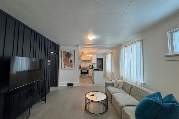 Living room with grey sectional sofa, coffee table, and view into the kitchen. - 263 Griffin Street, Treherne