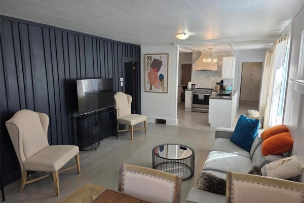 Living room and dining area with furniture, featuring a grey sofa and dining table with chairs. - 263 Griffin Street, Treherne