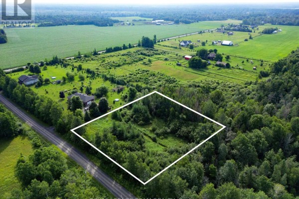 Drone shot of a spacious, undeveloped property surrounded by lush greenery. - 2630 Mcmullen Road, Ottawa