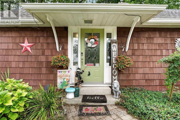 Front view of the residential house with a stone pathway, garden beds, and manicured lawn. - 2631 Thompson Road, Fort Erie