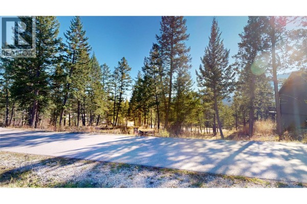 Wooded lot with tall evergreen trees and a view of a house. - 2636 Brewer Ridge Rise, Invermere