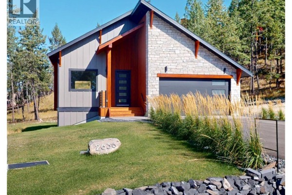 View from entrance into open-concept living space with modern kitchen, island, and light wood floors. - 2636 Taynton Trail, Invermere