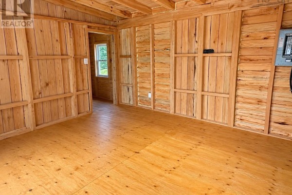 Interior of a wooden cabin with unfinished wood walls and a light wood floor. - 264 Beaver Dam Trail, Labelle