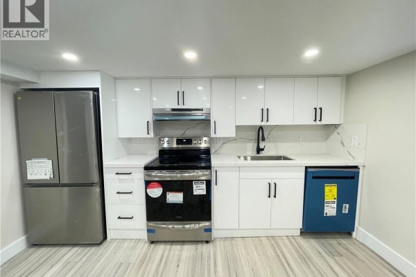 Open concept living area and kitchen with light wood-look flooring and recessed lighting. - 264 Thayer Avenue Unit# Lower, Hamilton