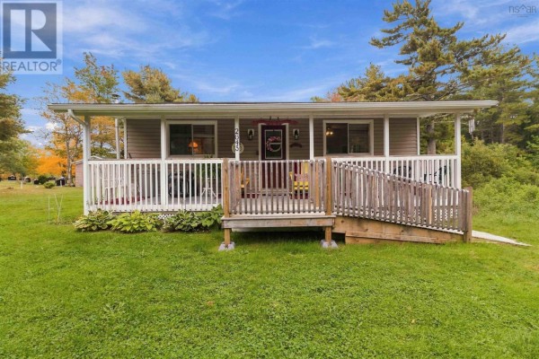 Front facade of a grey house with a white railing, wooden ramp, and porch. - 2643 Highway 210, Chelsea
