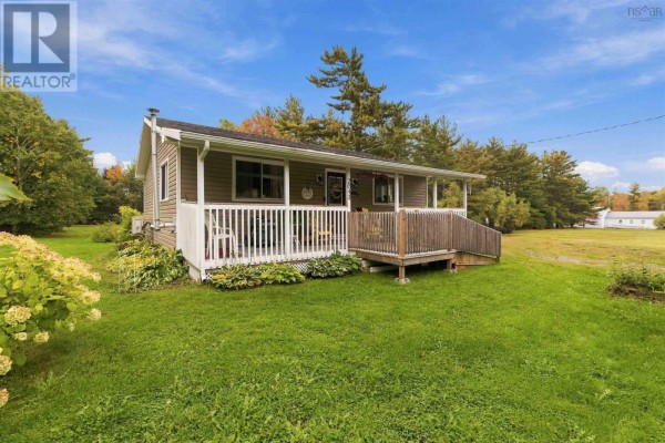 Side view of a single-story grey house with a covered porch and grassy lawn. - 2643 Highway 210, Chelsea
