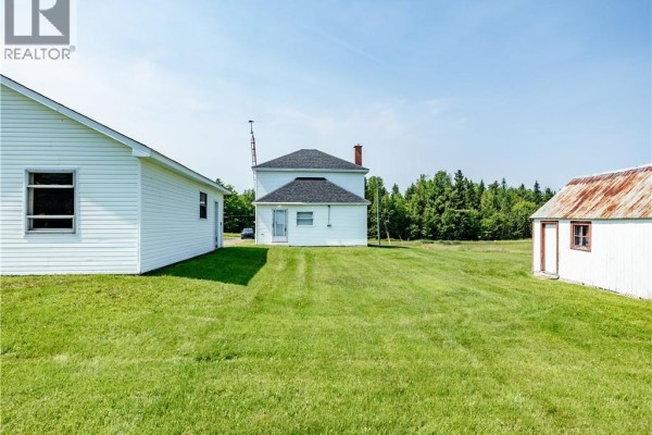 Interior of a two-car garage with concrete floor, workbench, and three windows. - 2649 Saint-ignace, Saint Ignace