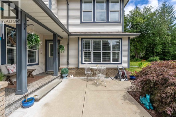 Interior view of a bright foyer with a blue front door, wood floors, and a staircase. - 26497 126 Avenue, Maple Ridge