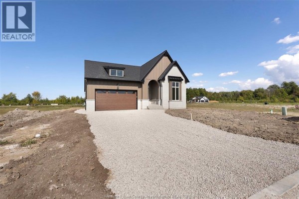 View of the house from the driveway, showing the modern exterior and surrounding undeveloped land. - 265 Charles Street, Essex