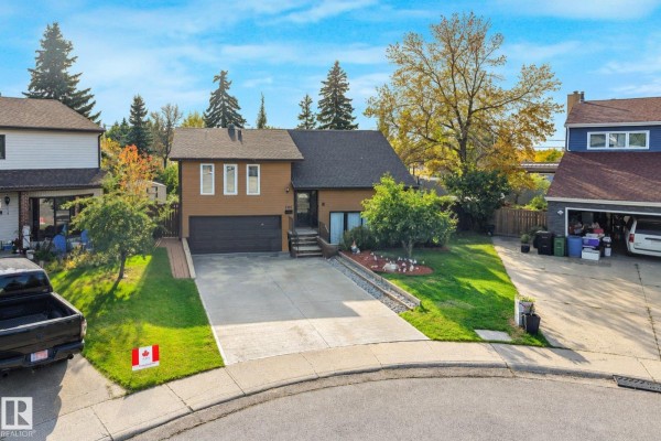 Drone view of the house showing the front yard, driveway with a truck, and surrounding properties. - 265 Grand Meadow Cr Nw, Edmonton