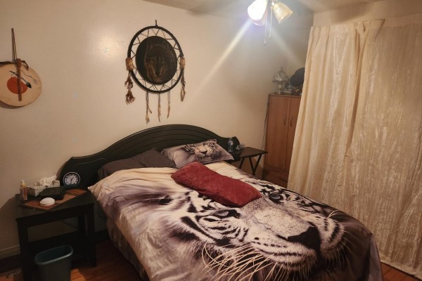 Bedroom with a twin bed, dresser, and decorative dreamcatcher on the wall. - 265 Rue Du Parc, Plaisance