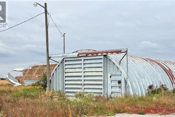 Quonset hut with large sliding doors and a damaged arched roof. - 266 Haldimand Rd 9 Road, Hagersville