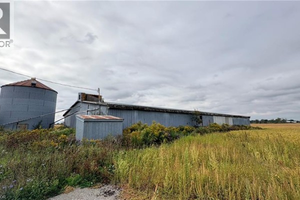 Long, grey metal barn with attached silos and a smaller shed. - 266 Haldimand Rd 9 Road, Hagersville