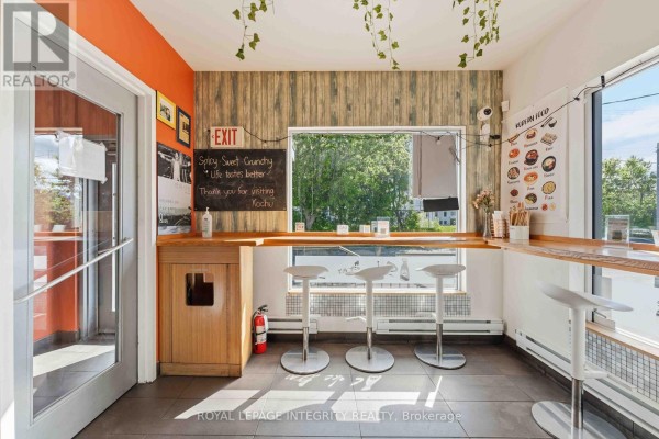 Interior dining space with a window counter, stools, and a menu board. - 266 Preston Street N, Ottawa