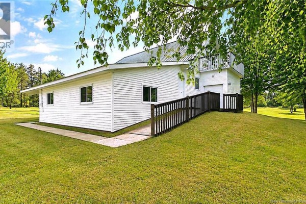 Side view of a detached white building with windows and a ramp leading to a doorway. - 2668 Rte 363, Saint Sauveur