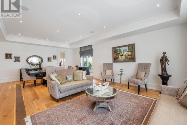 A living room and dining area with sofas, chairs, dining table, and hardwood floors. - 267 Empress Avenue, Toronto