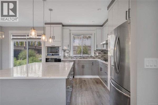 Open concept living area with a sofa, coffee table, and a small dining set. - 267 Golden Oaks Cres, Nanaimo
