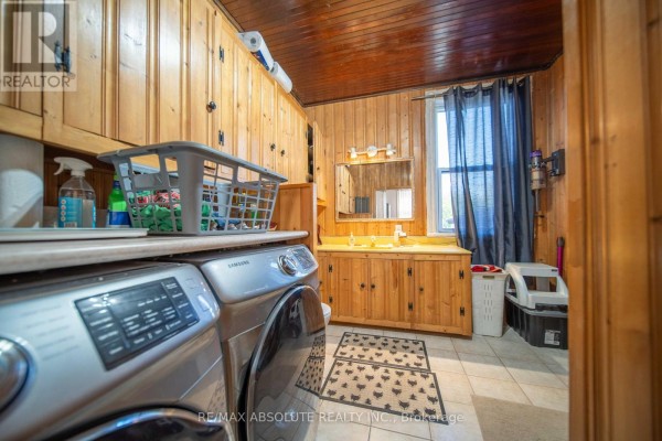 Laundry room with Samsung washer, vanity, and wood paneling - 2671 Champlain Street Clarence Rockland