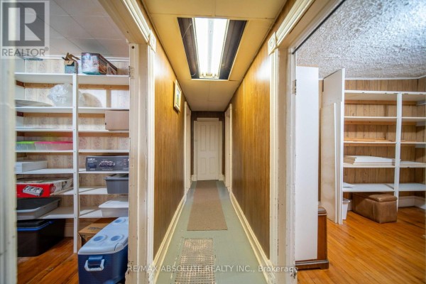 Wood paneled hallway with shelving and fluorescent lighting - 2671 Champlain Street Clarence Rockland
