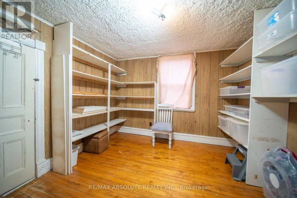Room with shelving, wood paneling, hardwood floors, chair, and window - 2671 Champlain Street Clarence Rockland