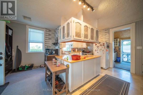 Kitchen with island, white cabinets, and outdoor access - 2671 Champlain Street Clarence Rockland