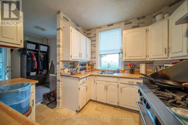 Kitchen with white cabinets, wood counters, gas range & coat closet - 2671 Champlain Street Clarence Rockland