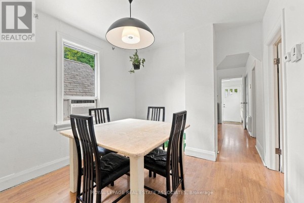Dining area with square table, four black chairs, and a modern pendant light. - 268 Troy Street, Mississauga