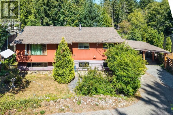 Outdoor seating area with gravel ground cover and a metal table and chairs. - 2682 Beaver Creek Cres, Nanaimo