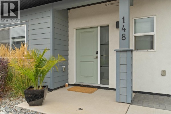 Close-up of the home's entrance with a light green door and house number 148. - 2683 Ord Road Unit# 148, Kamloops