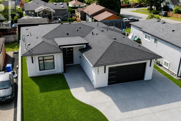 Aerial view of a modern white house with black roof and garage. - 2684 12th Ave, Port Alberni