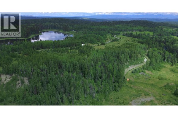 Aerial view of property with a lake, forest, and small structures. - 2685 Mile 108 Road, Horsefly