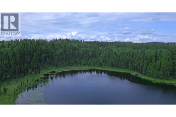 Close-up aerial view of a calm lake surrounded by dense forest. - 2685 Mile 108 Road, Horsefly