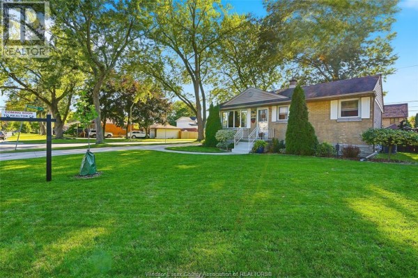 Aerial view showing the bungalow, its manicured lawn, adjacent properties, and surrounding neighborhood. - 2691 Askin, Windsor