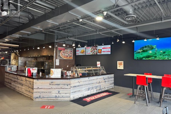 Interior view of Pizzaville counter with pizza display, seating, and digital menu board. - 27 - 1111 Davis Drive, Newmarket