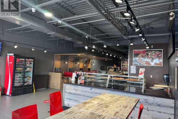 Interior view of Pizzaville showing counter, seating area, and drink cooler. - 27 - 1111 Davis Drive, Newmarket