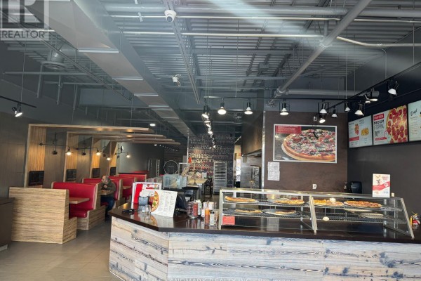 Interior view of Pizzaville with booth seating, counter, and pizza display. - 27 - 1111 Davis Drive, Newmarket