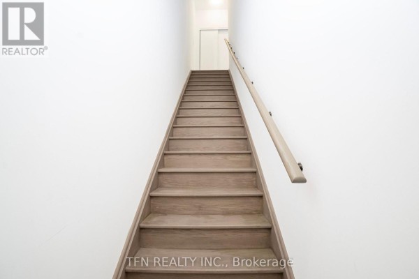 Wooden staircase with white walls and a beige handrail leading upwards. - 27 - 3020 Trailside Drive, Oakville