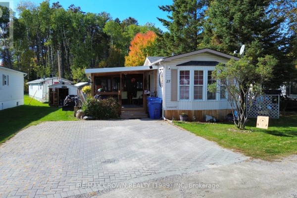 A close-up of the mobile home's front entrance with a covered porch and steps. - 27 - 395 Riverbend Road, North Bay