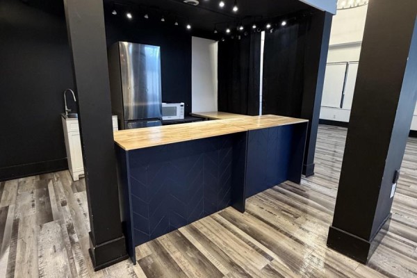 Close-up of a dark blue counter with a wood top and chevron pattern, next to a refrigerator and sink. - 27 - 501 Passmore Avenue, Toronto